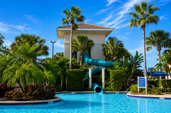 The pool complex at Omni Orlando Resort at ChampionsGate with palm trees and blue umbrellas